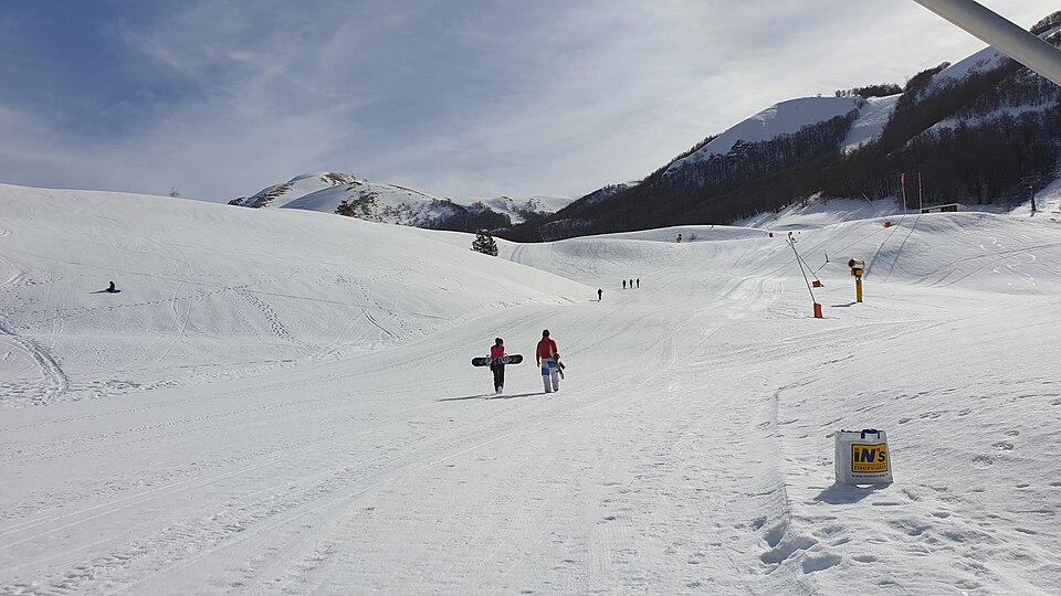 Due persone con snowboard su una pista innevata di Campo Felice.